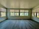 Bright sunroom with many windows providing natural light and neutral finishes, including grey wood-look tile flooring at 440 89Th Ave, St Pete Beach, FL 33706