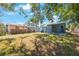 View of the back of the home and yard, surrounded by mature trees and green grass at 513 88Th N Ave, St Petersburg, FL 33702