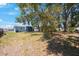 Expansive green backyard, partially shaded by a mature tree and attached to a charming single-story home at 513 88Th N Ave, St Petersburg, FL 33702