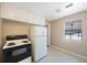 Standard kitchen features a white refrigerator and black and white stove with overhead cabinets at 513 88Th N Ave, St Petersburg, FL 33702