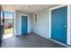 Covered front porch featuring two blue exterior doors with a small window between them at 513 88Th N Ave, St Petersburg, FL 33702
