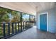 Covered porch overlooks fenced yard with water views and features an exterior door with blue trim at 513 88Th N Ave, St Petersburg, FL 33702