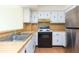 Kitchen area featuring a stainless steel refrigerator, black oven and a double-bowl sink at 5505 Puerta Del Sol S Blvd # 321, St Petersburg, FL 33715
