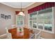 Dining room with wood table set for six, shuttered windows, and view of the pool at 5704 Eaglemount Cir, Lithia, FL 33547