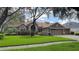 Charming one-story home featuring a manicured lawn, mature trees, and a welcoming three-car garage at 5704 Eaglemount Cir, Lithia, FL 33547