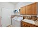 Functional laundry room with washer, dryer, sink, and ample storage space at 5704 Eaglemount Cir, Lithia, FL 33547