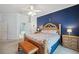 Main bedroom with a blue accent wall, ceiling fan, and ensuite bathroom with a soaking tub and walk-in shower at 5704 Eaglemount Cir, Lithia, FL 33547