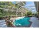 Screened-in pool and hot tub offer a private oasis surrounded by tropical plants at 5704 Eaglemount Cir, Lithia, FL 33547