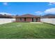 Spacious backyard featuring a well-maintained lawn, patio, and white picket fence at 5860 War Admiral Dr, Wesley Chapel, FL 33544