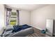 Simple bedroom featuring a bed, bright window with backyard views, and a full-length mirror at 5860 War Admiral Dr, Wesley Chapel, FL 33544