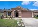 Charming single-story home with a well-manicured lawn and attached two-car garage at 5860 War Admiral Dr, Wesley Chapel, FL 33544