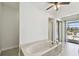 Bright bathroom features large soaking tub, walk-in shower and sliding glass doors to patio at 6119 Galleon Way, Tampa, FL 33615