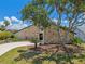 Charming home featuring stone accents, mature landscaping and a curved driveway at 6119 Galleon Way, Tampa, FL 33615