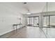 Bright living room features gray floors, mirrored wall and sliding door to patio with hot tub at 6119 Galleon Way, Tampa, FL 33615