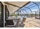 Enclosed patio area with a dining table set offers a scenic view of the pool and canal at 6119 Galleon Way, Tampa, FL 33615