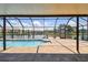 Screened-in pool area with a brick-paved patio and a serene canal view at 6119 Galleon Way, Tampa, FL 33615