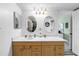 Bathroom vanity features double sinks, oval mirrors, modern lighting, and plenty of cabinet space for storage at 6265 Sun Blvd # 605, St Petersburg, FL 33715