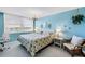 Bedroom with large window, water view, light blue walls and beachy decor accents at 6265 Sun Blvd # 605, St Petersburg, FL 33715