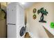 Convenient condo laundry area with stacked washer and dryer, plus practical shelving for storage at 6265 Sun Blvd # 605, St Petersburg, FL 33715