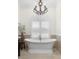 Elegant bathroom featuring a freestanding tub, shuttered window, and ornate chandelier at 703 Monte Cristo Blvd, Tierra Verde, FL 33715