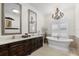 Elegant bathroom featuring dual sinks, a freestanding tub, and a modern chandelier at 703 Monte Cristo Blvd, Tierra Verde, FL 33715