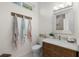 Well-lit bathroom featuring a wood vanity, stylish mirror, and decorative towel rack at 703 Monte Cristo Blvd, Tierra Verde, FL 33715