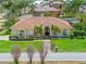 Beautiful home featuring lush landscaping, tiled roof, and a manicured front lawn at 703 Monte Cristo Blvd, Tierra Verde, FL 33715