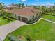 Well maintained home featuring a 2-car garage, tiled roof, and a manicured front lawn at 703 Monte Cristo Blvd, Tierra Verde, FL 33715