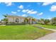 Beautiful Mediterranean-style home with tile roof, manicured lawn, lush landscaping, and a stone walkway to the front door at 703 Monte Cristo Blvd, Tierra Verde, FL 33715