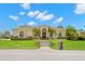Beautiful Mediterranean-style home with tile roof, manicured lawn, lush landscaping, and a stone walkway to the front door at 703 Monte Cristo Blvd, Tierra Verde, FL 33715