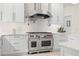 Gourmet kitchen featuring a Wolf range, stainless hood, and white marble countertops at 703 Monte Cristo Blvd, Tierra Verde, FL 33715