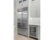 Modern kitchen featuring stainless steel refrigerator, white cabinets, and built-in wine cooler for beverage storage at 703 Monte Cristo Blvd, Tierra Verde, FL 33715