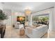 Bright living room with a modern chandelier, neutral furniture and view of the screened-in pool area at 703 Monte Cristo Blvd, Tierra Verde, FL 33715
