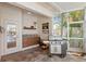 Outdoor kitchen featuring tiled floors, wood cabinets, stainless steel grill, and screened windows overlooking the pool area at 703 Monte Cristo Blvd, Tierra Verde, FL 33715