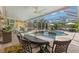Screened-in patio with an outdoor dining area, ceiling fans and a view of the pool at 703 Monte Cristo Blvd, Tierra Verde, FL 33715