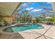 Beautiful screened-in pool and spa area with a clear view of the tropical landscaping, creating a private backyard at 703 Monte Cristo Blvd, Tierra Verde, FL 33715