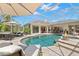 Inviting screened-in pool featuring a spa, fire bowls, and ample seating areas for relaxation and entertaining at 703 Monte Cristo Blvd, Tierra Verde, FL 33715