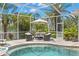 Relaxing screened-in spa area with tropical landscaping providing a private oasis for unwinding at 703 Monte Cristo Blvd, Tierra Verde, FL 33715