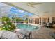 Inviting screened-in pool with cozy seating areas and a view of the lush tropical landscaping at 703 Monte Cristo Blvd, Tierra Verde, FL 33715