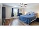 Bedroom featuring wood floors, ceiling fan, and a comfortable blue comforter at 7170 Samuel Ivy Dr, Tampa, FL 33619