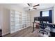 Well-lit bedroom featuring a ceiling fan, wood floors, a large built-in bookshelf and a desk at 7170 Samuel Ivy Dr, Tampa, FL 33619