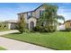 Charming two-story home with a well-manicured lawn and lush landscaping creating a welcoming curb appeal at 7170 Samuel Ivy Dr, Tampa, FL 33619