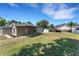 Spacious backyard featuring lush green grass and various storage and car port structures on a sunny day at 7222 N Amos Ave, Tampa, FL 33614