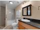 Modern bathroom featuring wood cabinets, granite counters, tiled shower with glass door and fixtures at 7222 N Amos Ave, Tampa, FL 33614