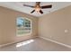 Cozy bedroom with tile flooring, a modern ceiling fan, and a picturesque arched window at 7222 N Amos Ave, Tampa, FL 33614