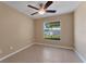 Bright bedroom with tile floors, a modern ceiling fan, and a large window offering natural light at 7222 N Amos Ave, Tampa, FL 33614
