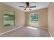 Bedroom featuring neutral walls, two windows offering view of fenced back yard, and tile floors at 7222 N Amos Ave, Tampa, FL 33614
