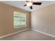 Cozy bedroom with tile floor, neutral tones, and a window overlooking the backyard at 7222 N Amos Ave, Tampa, FL 33614