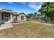 Side view of the home, showcasing the well-maintained lawn, carport and utility shed on a sunny day at 7222 N Amos Ave, Tampa, FL 33614