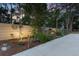 A well-maintained fence with a cute shed, set against a stunning sunset backdrop and lush landscaping at 7507 Beasley Rd, Tampa, FL 33615